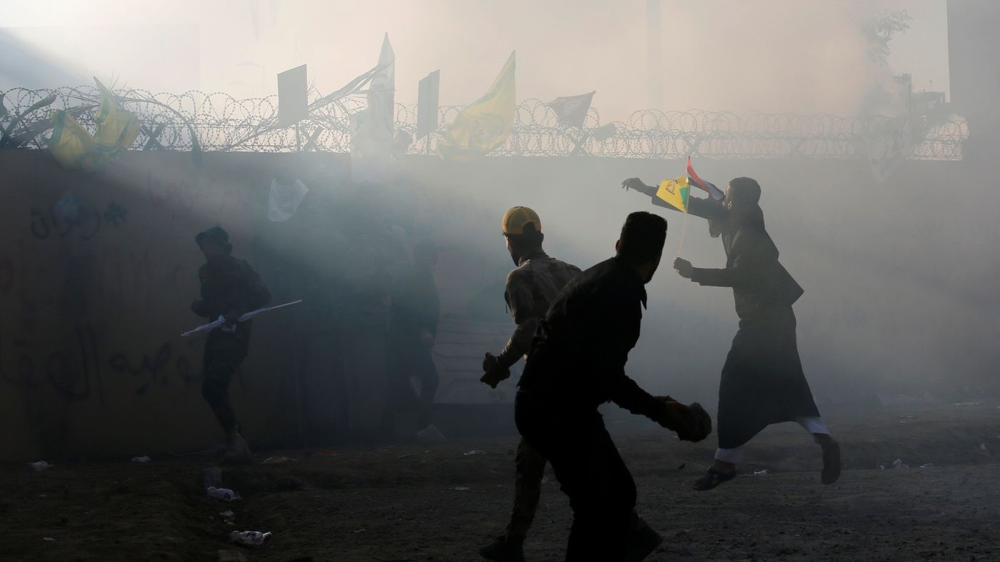 Người biểu tình và binh lính ném đá vào tòa đại sứ Mỹ ở Baghdad, Iraw, ngày 31/12/2019. Ảnh: Reuters.
