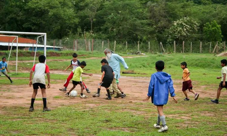 Sadhguru chơi bóng với trẻ em nông thôn Ấn Độ. Ảnh: sadhguru.org.