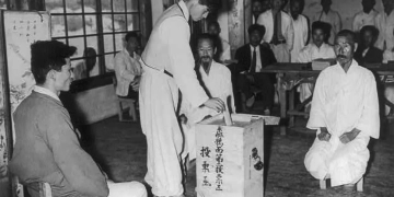 Một cử tri Nam Hàn bỏ phiếu trong Cuộc tổng tuyển cử Quốc hội Lập pháp vào ngày 10 tháng 5 năm 1948 dưới sự chứng kiến của các nhân viên giám sát bầu cử tại Nae Chon, Hàn Quốc. Nguồn ảnh: U.S. Army.